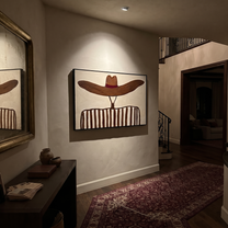 Brown Waves Hide the Face - Undulating Hat Portrait painting by Adrian Lee, mid-century modern horizontal wall art – styled room scene view 5