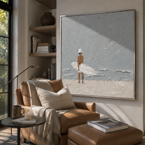 Quiet Surf Finds the Gray Sky - Minimal Surfer on Pale Beach painting by Claire Whitmore, modern coastal square wall art – styled room scene view 2