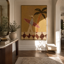 Checkered Board Crosses the Sand - Tall Surfer beneath Palm painting by Claire Whitmore, modern coastal vertical wall art – styled room scene view 1
