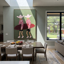 Twin Hats Carry Burgundy - surfboard figure pair painting by Claire Whitmore, modern coastal vertical wall art – styled room scene view 4