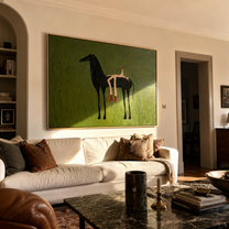Olive Field Stretches Wide – Black Horse and Red Boots painting by Isabelle Laurent, modern Western horizontal wall art – styled room scene view 5