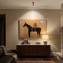 Pale Loop Finds Rider - black horse rider painting by Isabelle Laurent, modern Western horizontal wall art – styled room scene view 2