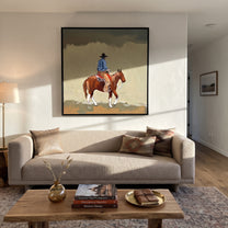 Dusty Trail Carries Home - cowboy trail horse painting by Isabelle Laurent, modern Western square wall art – styled room scene view 3