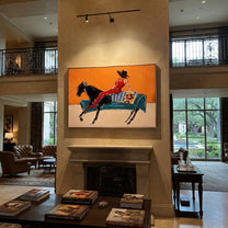 Red Boots Chase Orange - reclining horse rider painting by Isabelle Laurent, modern Western horizontal wall art – styled room scene view 5
