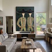 Black Hats Shelter Green - green robe figure pair painting by Elliot Vale, modern figurative vertical wall art – styled room scene view 1