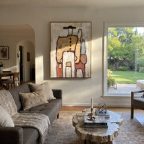 Bags Wait Beside Figures - abstract traveler family painting by Elliot Vale, modern figurative vertical wall art - styled room scene view 1