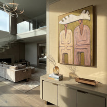 Pink Coats Share Antler - antler hat figure pair painting by Elliot Vale, modern figurative vertical wall art - styled room scene view 3