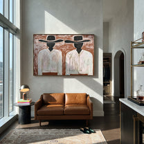 Black Faces Hold White - black face figure pair painting by Elliot Vale, modern figurative horizontal wall art - styled room scene view 3