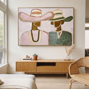 Pink Hat Meets Green - pastel hat figure pair painting by Elliot Vale, modern figurative horizontal wall art - styled room scene view 1