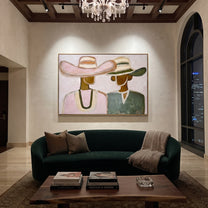 Pink Hat Meets Green - pastel hat figure pair painting by Elliot Vale, modern figurative horizontal wall art - styled room scene view 4
