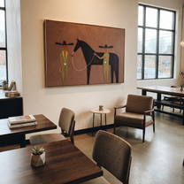 Two Riders Share Reins - horse handler pair painting by Elliot Vale, modern figurative horizontal wall art - styled room scene view 3