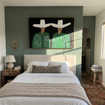 White Geometry Guards Green - geometric hat figure pair painting by Elliot Vale, modern figurative horizontal wall art - styled room scene view 2