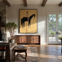 Black Horse Crosses Gold - minimal horse rider painting by Elliot Vale, modern figurative vertical wall art - styled room scene view 4