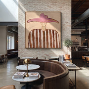 Rose Wings Float Softly - brown striped hat figure painting by Elliot Vale, modern figurative square wall art - styled room scene view 1