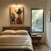 Black Brim Shelters Trust - cowgirl horse closeup painting by Ethan Mercer, contemporary Western vertical wall art – styled room scene view 3