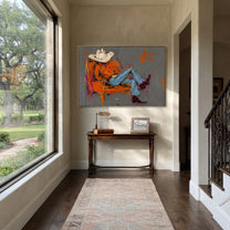 Orange Chair Spans Gray - reclining cowboy chair painting by Ethan Mercer, contemporary Western horizontal wall art – styled room scene view 5
