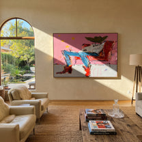 Red Chair Drifts Pink - reclining cowboy chair painting by Ethan Mercer, contemporary Western horizontal wall art – styled room scene view 2
