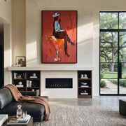 Crimson Glass Carries Rider - cowboy riding cocktail painting by Ethan Mercer, contemporary Western vertical wall art – styled room scene view 1